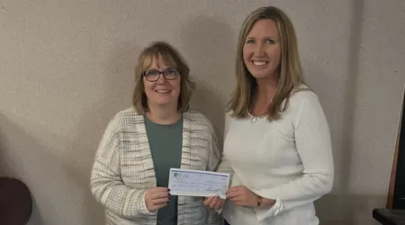 AAACU Team member presents a check to a member of the Cheboygan High School Senior Class of 2025